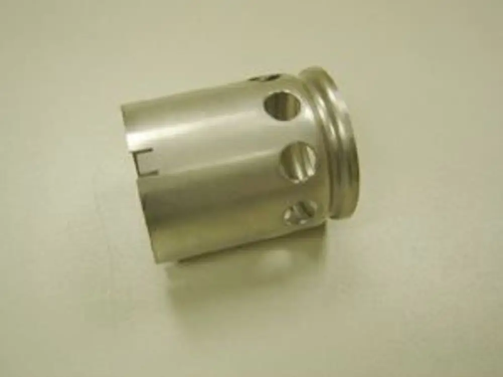 Metallisches Bauteil mit mehreren Öffnungen und einem abgerundeten oberen Rand, möglicherweise Teil eines Heizungs- oder Lüftungssystems von Remeha.